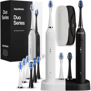 The AquaSonic DUO dual handle electric toothbrush set includes a midnight black and an optic white toothbrush, a wireless charging dock, 10 DuPont brush heads, and two travel cases for convenient and complete oral care.