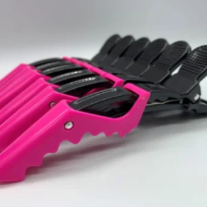 A plastic crocodile shaped hair clip, used for styling and sectioning hair.