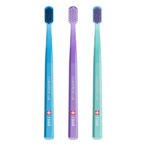 A 3-pack of Curaprox 1560 soft toothbrushes in assorted colors for gentle and effective cleaning.