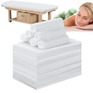 This image shows 100 disposable white massage table sheets, sized 31x71 inches, made of soft, waterproof, non-woven fabric, suitable for spas, beauty salons, and tattoo parlors.