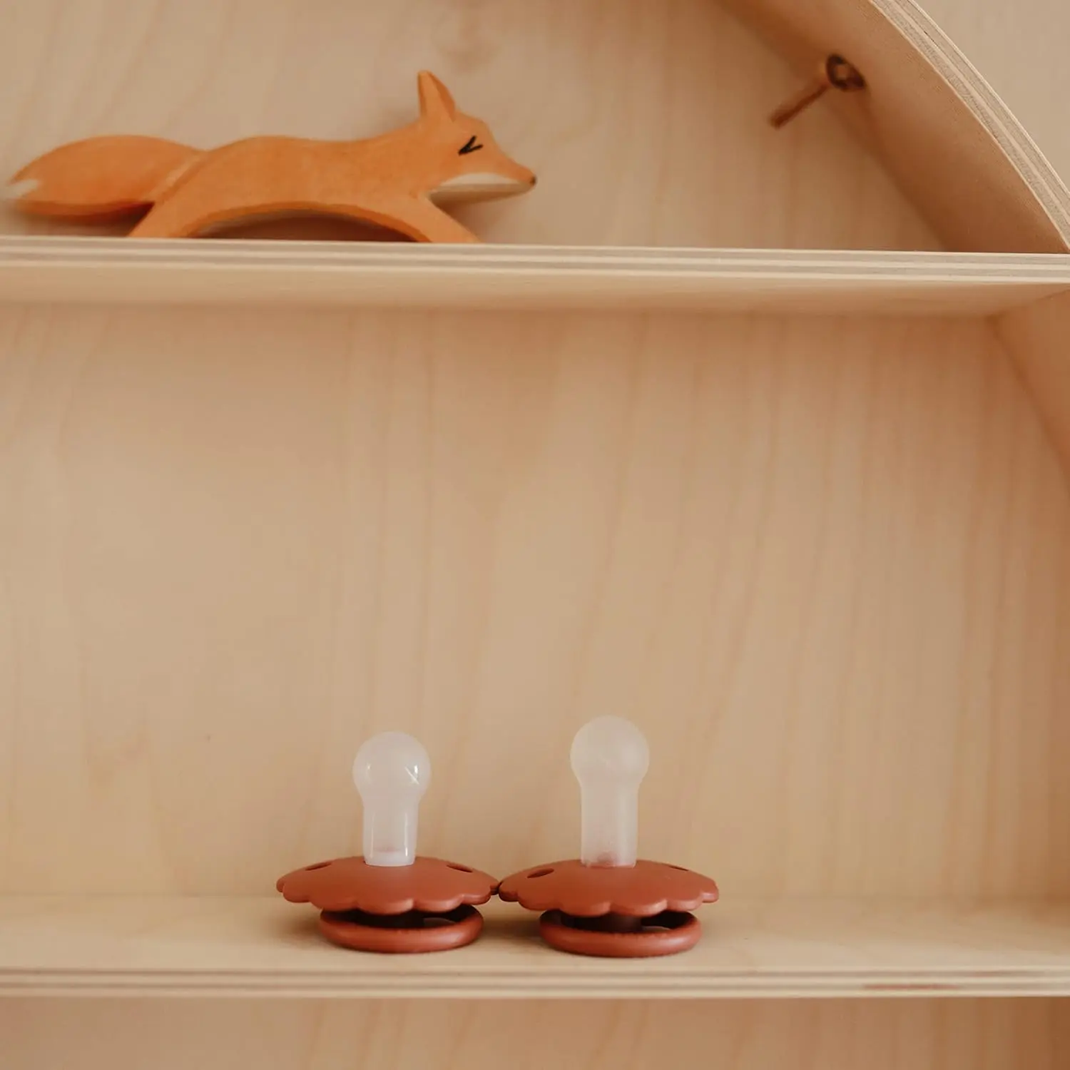 Two-pack of FRIGG Daisy pacifiers in baked clay and cream colors, size 2, designed for babies 6-18 months and made with SilkySoft medical grade silicone.