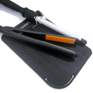 Large black silicone heat resistant mat protects surfaces from hot curling irons and flat irons.