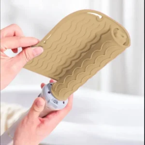 This pink silicone heat mat protects surfaces from damage caused by hot hair styling tools like curling irons and flat irons, making it perfect for travel or salon use.