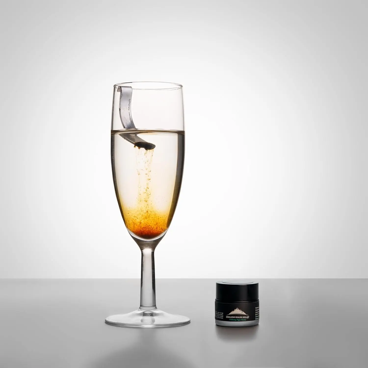 A jar of pure Himalayan Shilajit resin, a potent rejuvenator sourced from 16000 feet, known for its anti-aging properties.