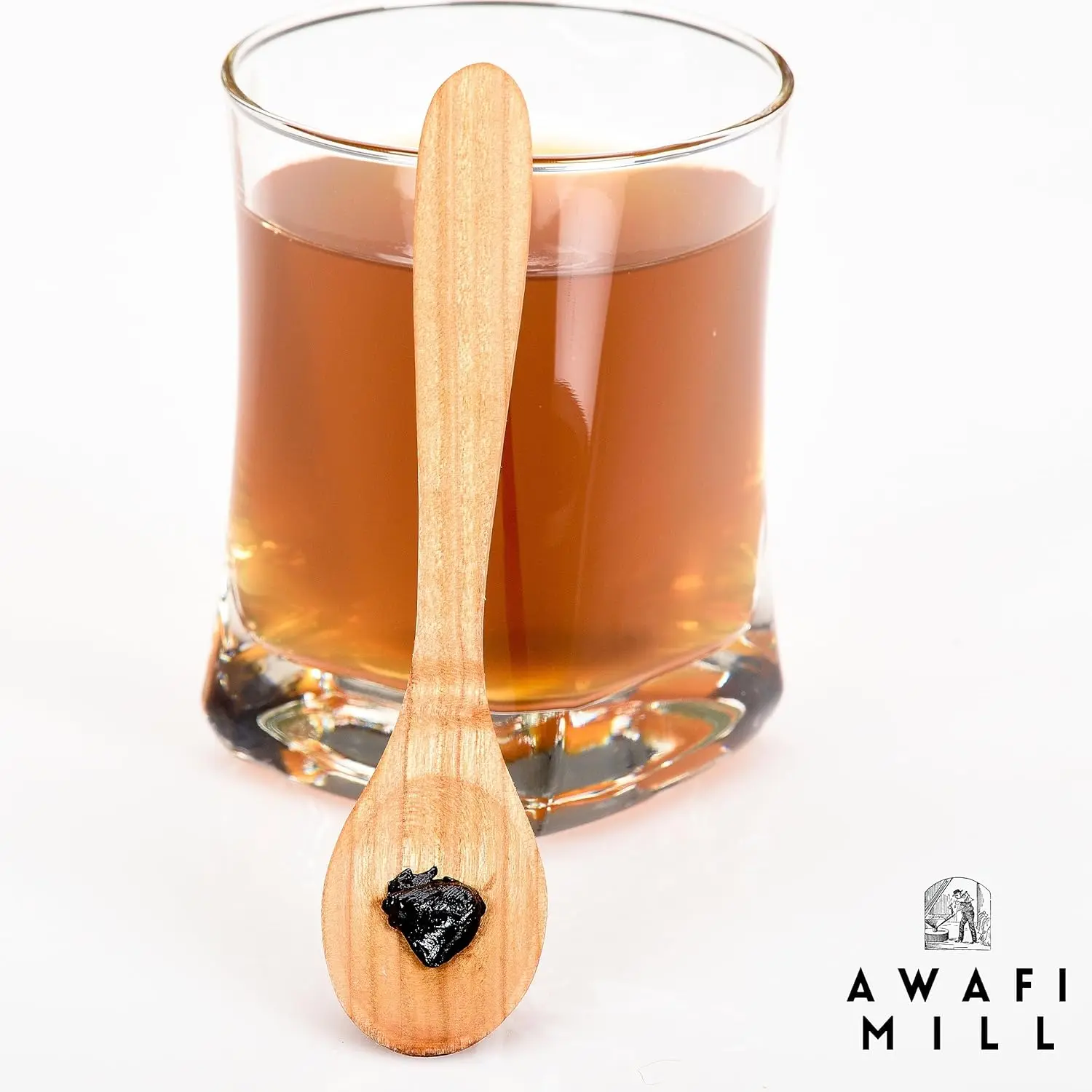 Dark brown Himalayan Shilajit resin chunks from Awafi Mill, ready to dissolve in warm water for a natural mineral supplement.