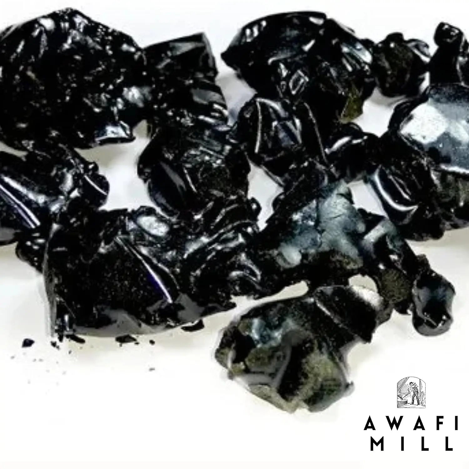 Dark brown Himalayan Shilajit resin chunks from Awafi Mill, ready to dissolve in warm water for a natural mineral supplement.
