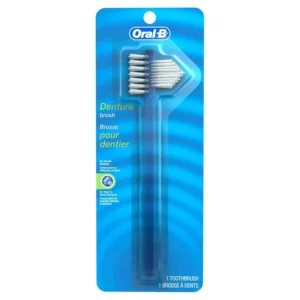 This Oral-B denture brush features a large, multi-tufted brush head and a smaller, angle-trimmed brush head with firm nylon bristles, attached to a large, easy-grip handle.