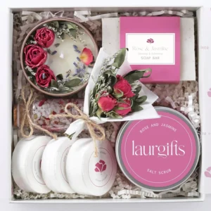 This small rose and jasmine spa gift box is perfect for birthdays, Mother's Day, or Teacher Appreciation, containing a candle, shower steamers, soap, bath salts, salt scrub, and dried flowers for a romantic and relaxing at-home spa experience.