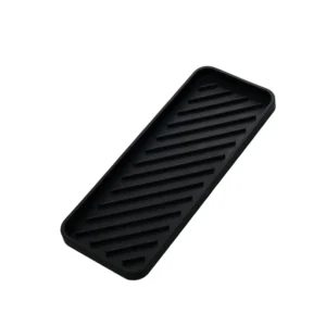Black silicone heat resistant mat for curling iron and hair straightener, protecting vanity countertop from heat damage.