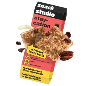 A healthy and natural snack bar from Snack Studio Stay-Cation, made with coconut, cranberries, and pecans for a guilt-free, plant-based snacking experience.