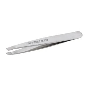 A mini stainless steel Tweezerman slant tweezer, ideal for travel and perfectly aligned for expert brow shaping.